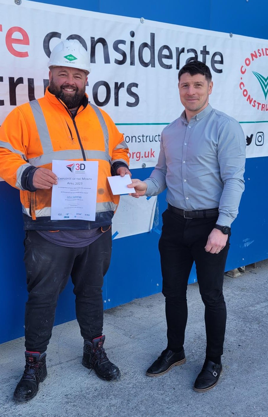 John is presented with his award by Brian out on site